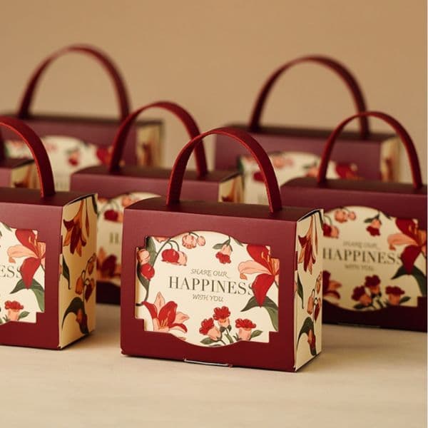 Multi colored lily flower pattern recycled material cardboard gift box with leather handle and window design, suitable for wedding candy packaging, gold color
