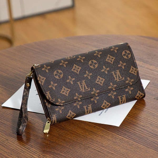 The lady is holding a stylish bag with large capacity and letter-patterned design. It is a wrist bag that can be carried on the shoulder.