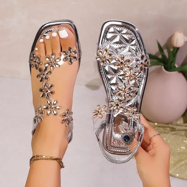 A pair of womens square-toe flat sandals stylish silver sandals adorned with floral decorations 260407