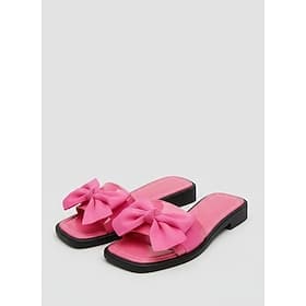 Leuchtend pinkfarbene Damen-Sandalen mit Schleife – schicke, flache Pantoletten mit eckiger Zehenpartie und übergroßen Zierknoten für luxuriöse Hotelurlaube un
