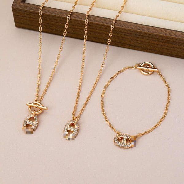 Luxury letter-embellished pig nose OT clasp bracelet necklace set with full diamond accents, elegant design and high-end feel