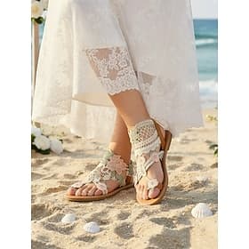 Sandalias de novia bohemias con encaje floral y tira en el tobillo: zapatos planos para una boda en la playa.